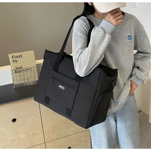 Borsa da viaggio nera di grande capacità per donna portata a spalla con stile moderno