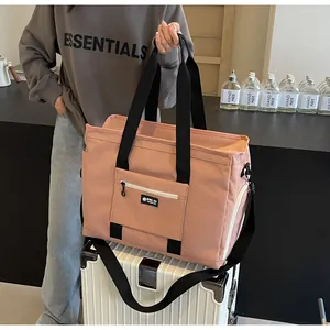Borsa da viaggio rosa capiente posata su una valigia bianca per mostrare l'uso