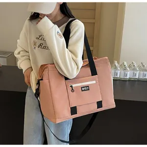 Borsa da viaggio rosa capiente portata da una modella in una calda scena di vita quotidiana