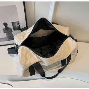 Detailed interior view of quilted cream travel duffle bag showing spacious black lining