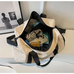 Interior view of cream quilted travel duffel bag showing large storage capacity