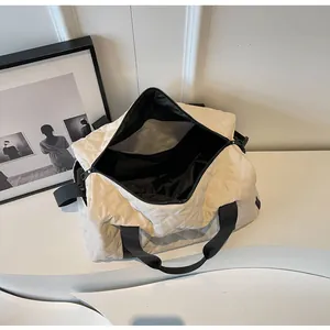 Detail of the spacious black interior and cream quilted pattern of this stylish travel bag
