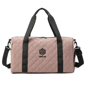 Detail view of the pink quilted duffel bag showing the brand logo and texture.