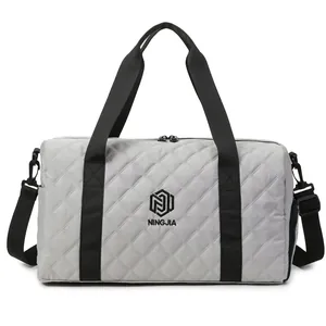 Front view of a quilted gray travel duffel bag with black handles and NINGJIA logo detail
