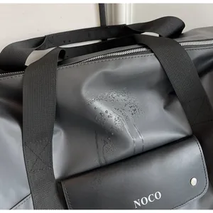 Detailopname van waterdichte stof en logo op een grote reistas voor reizen