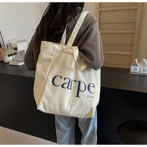 View of the carpe printed canvas tote bag worn by a model in a cozy cafe setting