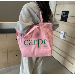 Lifestyle shot of a large pink canvas tote bag with 'carpe dienn' print over shoulder