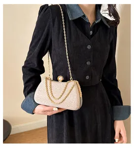 Elegant champagne glitter evening clutch bag with gold chain strap and pearl clasp
