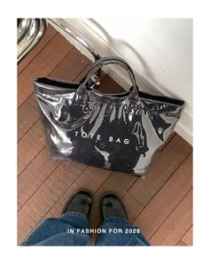 Vue détaillée d'un sac cabas en PVC noir brillant avec des motifs floraux.