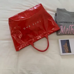 Sac cabas rouge en PVC brillant, sac jelly imperméable avec motifs floraux au laser.