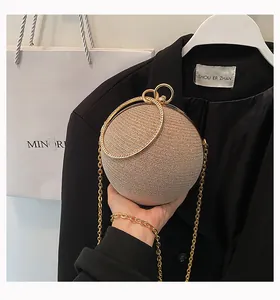Elegant spherical evening clutch bag with glitter rhinestones and gold ring handles.