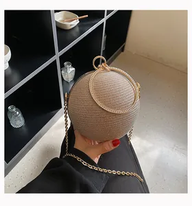 Close-up view of a luxury glittery spherical evening clutch bag with rhinestone handle