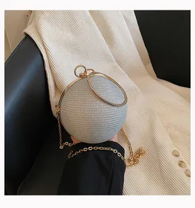 Detailed view of spherical silver shimmering clutch with gold rhinestone ring handle