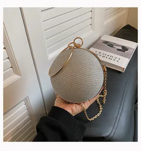 Detailed view of a silver spherical evening clutch with gold chain strap