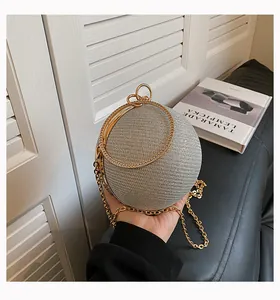 Detailed view of a luxury silver shimmering spherical evening bag with elegant gold chain