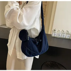 Fashionable large capacity dark blue denim tote bag worn as a crossbody messenger