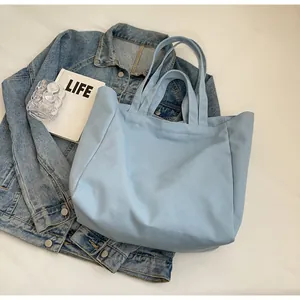 Detailed view of a light blue large capacity canvas tote bag for students.