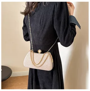 Elegant champagne gold glitter evening clutch bag featuring pearl clasp and gold chain.