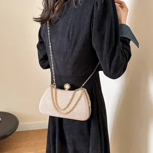 Elegant champagne gold evening clutch with pearl clasp and multi-chain strap detail