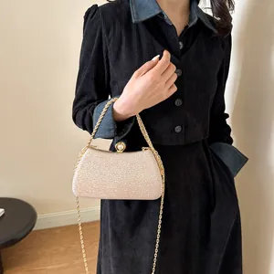 Elegant glittery champagne evening clutch bag with gold chain and pearl clasp detail.