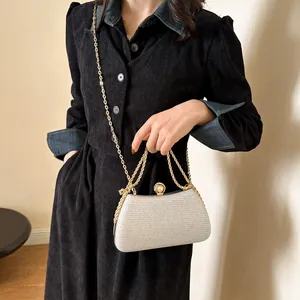 Elegant silver glitter evening clutch bag with gold chain strap detail view.