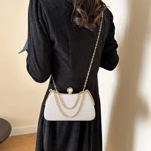 Elegant silver glitter evening clutch bag featuring a pearl clasp and golden chain strap