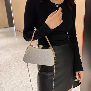 Detailed view of an elegant silver sparkly evening clutch bag with a gold chain strap