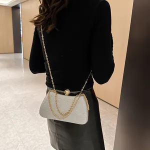 Elegant silver glitter evening clutch bag with gold chain strap and pearl clasp detail