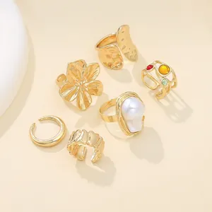 Detailansicht von 6 goldfarbenen Ringen mit Barockperlen und filigranen Blumen.