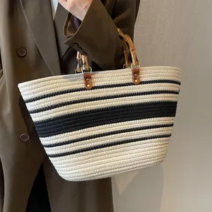 Bolso tote tejido elegante con diseño de rayas y asas de bambú distintivas para mujer.