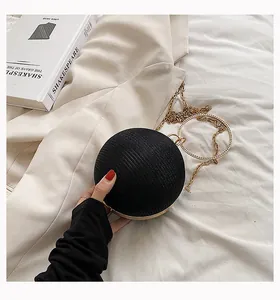 Detailed close-up of a black spherical evening clutch featuring a crystal ring handle