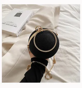 Detailed view of an elegant black spherical evening bag with a gold diamond handle