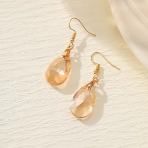 Detailansicht eleganter champagnerfarbener Zirkonia-Ohrringe in Tropfenform mit Goldhaken.