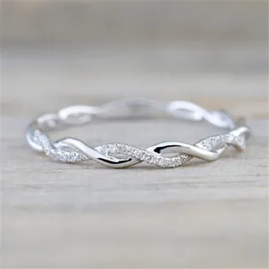 Macro detail view of a silver twisted wedding ring with shimmering pave stones