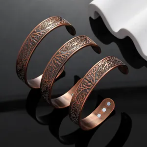 Detailansicht von magnetischen Kupferarmbändern im Retro-Stil mit Lebensbaum-Muster.
