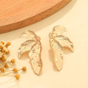 Close-up view of vintage gold-tone leaf earrings with textured alloy finish.