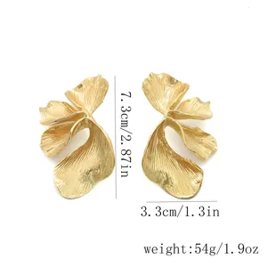 Close-up detail of large gold textured petal earrings with size and weight specs