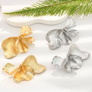 Detailed view of gold and silver vintage striped flower leaf earrings with 3D texture.