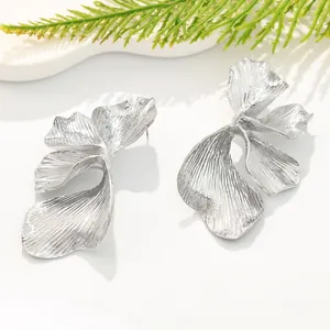 Detailed view of silver layered flower earrings with vintage striped texture.