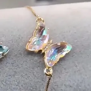 Detailansicht eines goldenen Schmetterlingsarmbands mit bunten Regenbogen-Zirkoniasteinen
