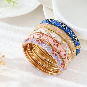 Primer plano de brazaletes apilables de esmalte de colores con diseños de flores y tréboles.