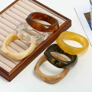 Detailed view of irregular marbled resin bangles in multiple colors on a display tray
