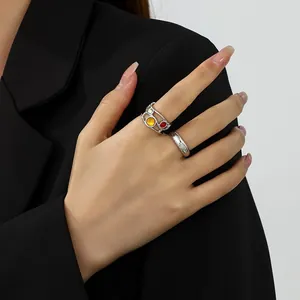 Detailansicht eines flüssigen Lavarings aus Silber mit bunten Edelsteinen an einer Hand.