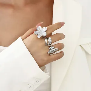 Detailansicht von drei silbernen flüssigen Lava und Blumenringen an einer Hand
