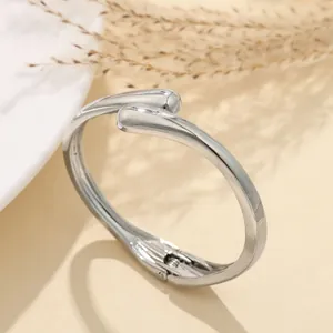 Vista dettagliata del bracciale rigido argento minimalista con motivo a onde irregolari