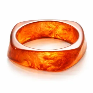 Fashionable irregular marbled resin bangle in amber with glossy polished finish.