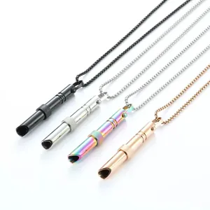Dettaglio macro di collane a fischietto per meditazione in quattro colori metallici