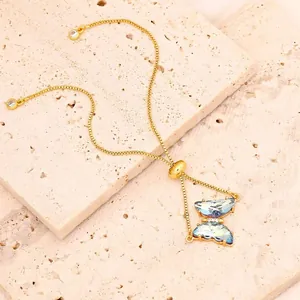 Elegante Detailansicht eines blauen Zirkon-Schmetterlingsarmbands mit Goldkette