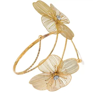Gedetailleerde weergave van een gouden opengewerkte bloemenarmband met kristallen