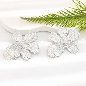 Detailed macro shot of vintage silver five-petal flower earrings with textured finish